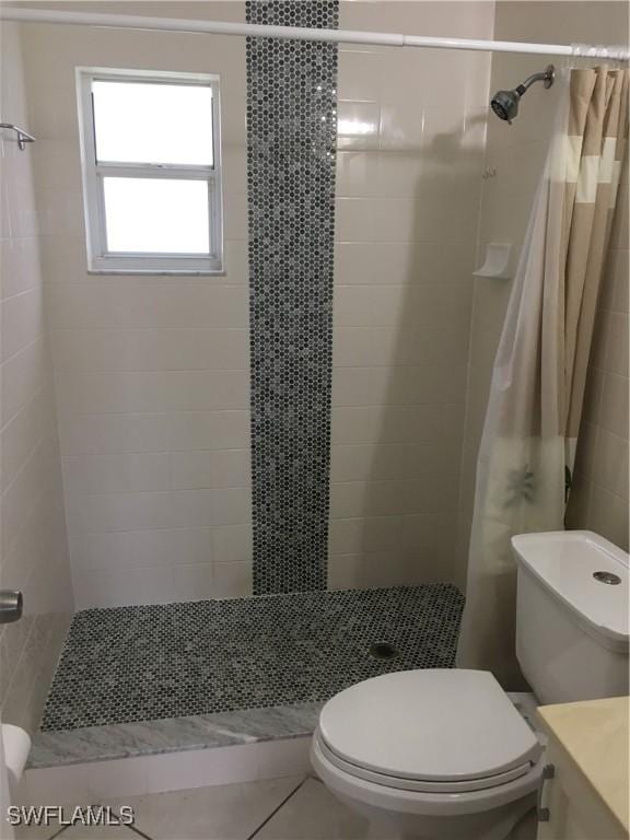 bathroom featuring a shower with shower curtain, tile patterned flooring, vanity, and toilet