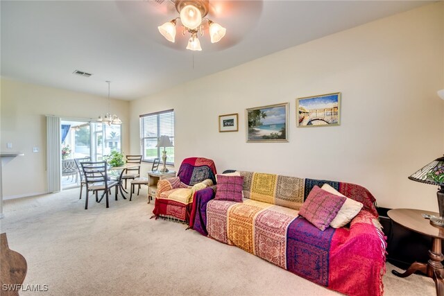 living room featuring ceiling fan with notable chandelier and light colored carpet