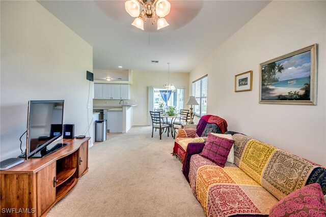 carpeted living room with ceiling fan with notable chandelier