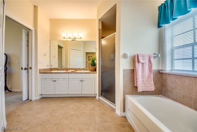 bathroom featuring shower with separate bathtub, tile patterned floors, and vanity