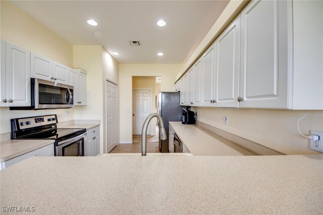 kitchen with white cabinets and appliances with stainless steel finishes