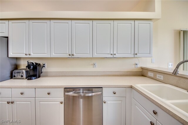 kitchen with stainless steel dishwasher, white cabinets, and sink