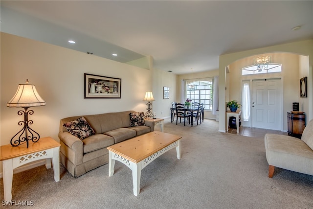 living room featuring light carpet and a chandelier