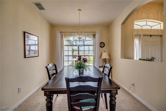 dining area featuring a notable chandelier and carpet flooring