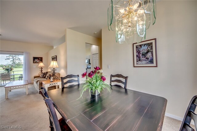 dining room with carpet flooring and a chandelier