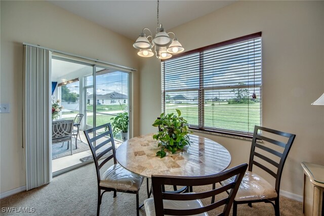 carpeted dining area with an inviting chandelier