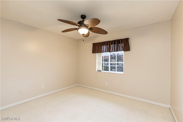 carpeted spare room featuring a textured ceiling and ceiling fan