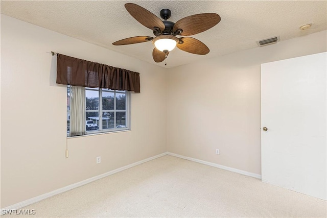 empty room featuring light carpet, ceiling fan, and a textured ceiling