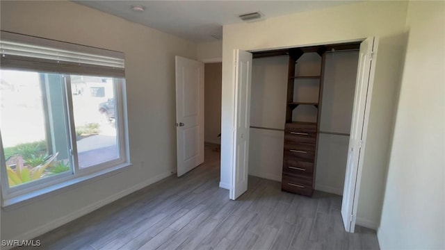 unfurnished bedroom with light hardwood / wood-style floors and a closet