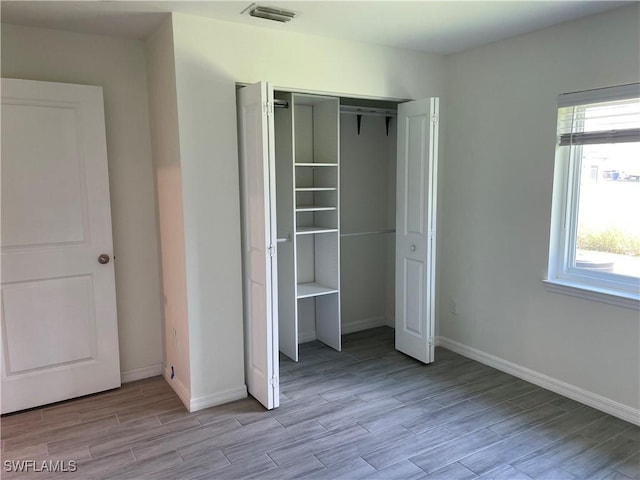 unfurnished bedroom with light hardwood / wood-style floors and a closet