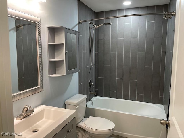 full bathroom featuring tiled shower / bath, vanity, and toilet