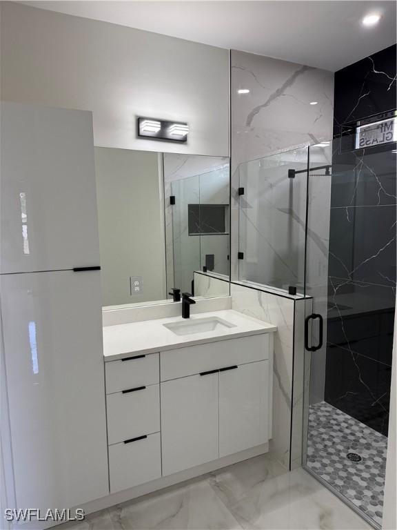 bathroom with a shower with door and vanity