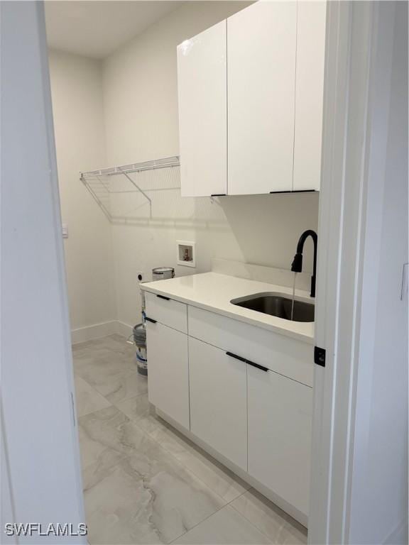 laundry room featuring electric dryer hookup, cabinets, washer hookup, and sink