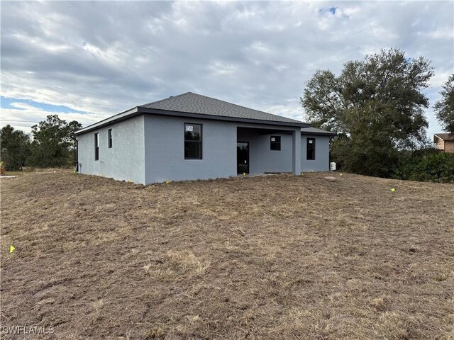 back of property featuring a lawn