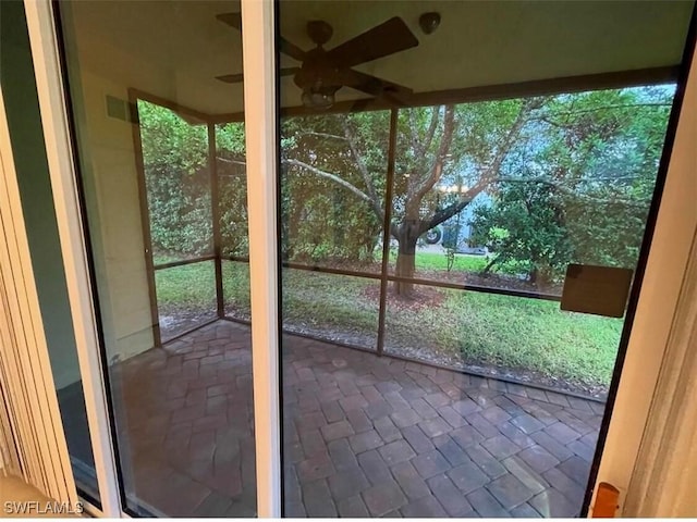 unfurnished sunroom featuring ceiling fan