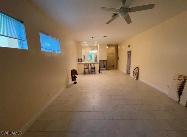 interior space with ceiling fan with notable chandelier