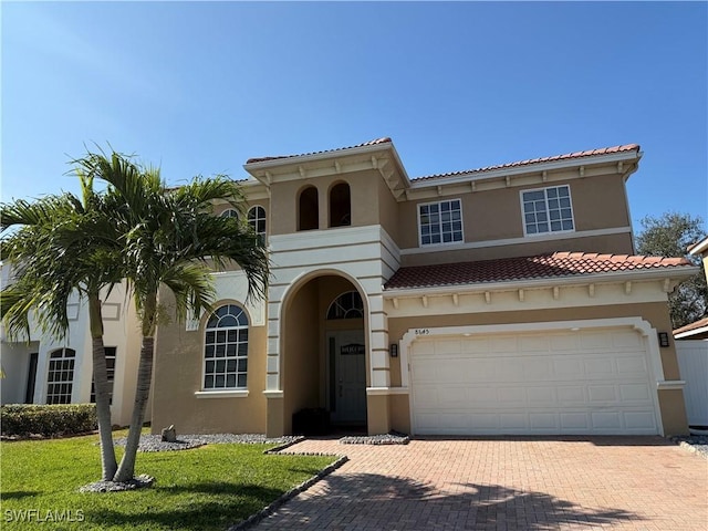 mediterranean / spanish-style house with a front yard and a garage