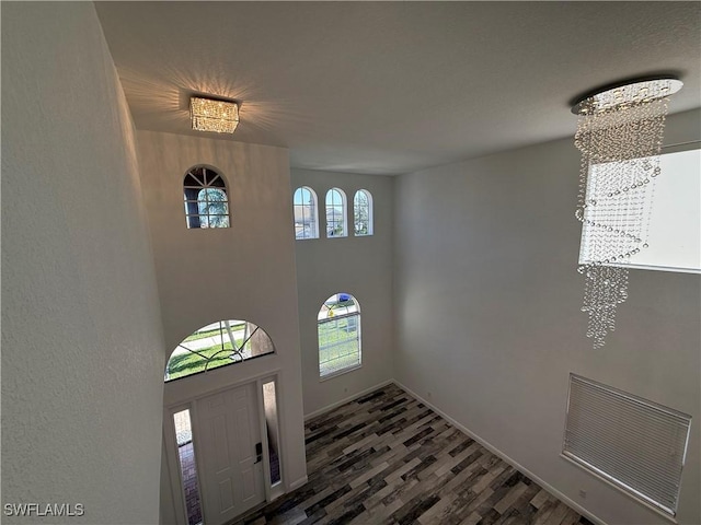 foyer with an inviting chandelier and dark hardwood / wood-style flooring