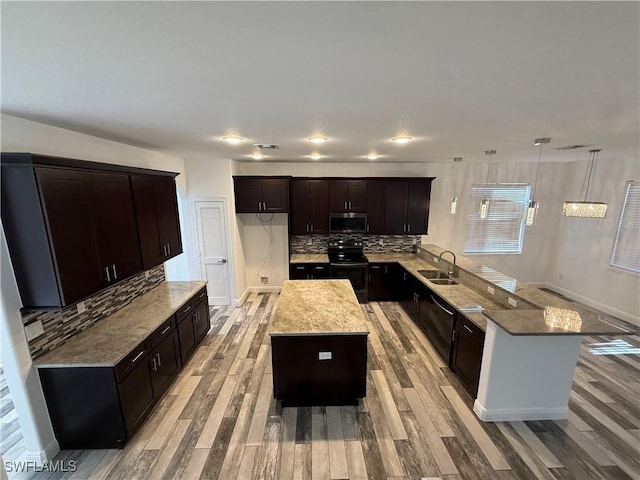 kitchen featuring a kitchen island, range with electric stovetop, backsplash, and hanging light fixtures