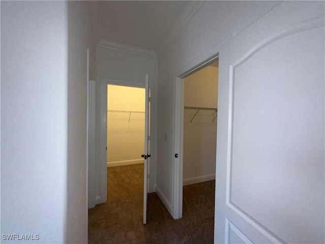 hallway featuring dark carpet and crown molding