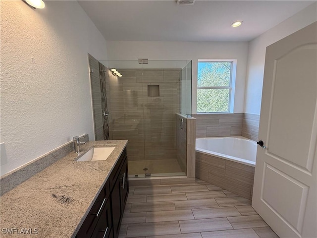 bathroom featuring separate shower and tub and vanity