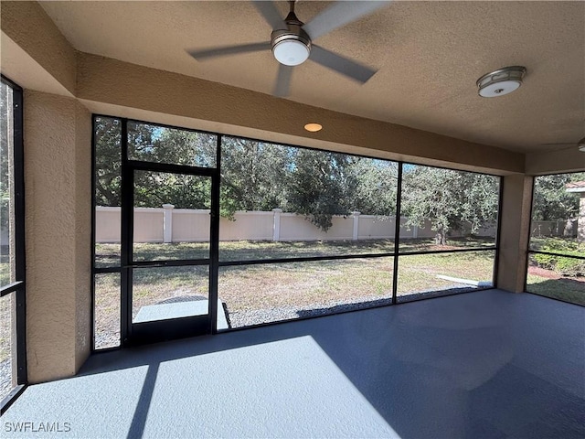 unfurnished sunroom with ceiling fan