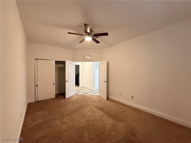 unfurnished bedroom with ceiling fan, a closet, and dark carpet