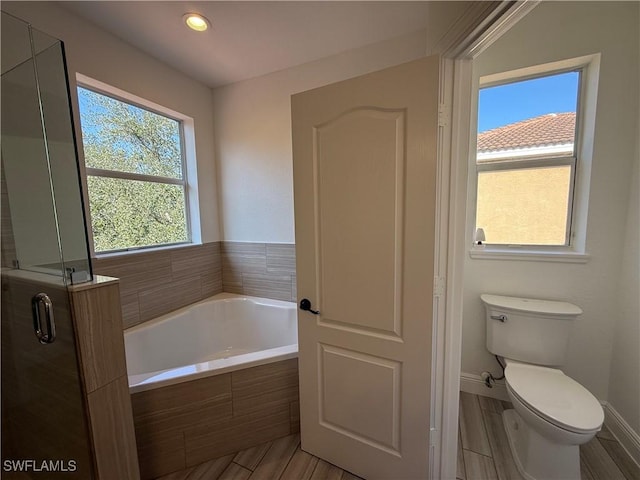 bathroom featuring toilet and independent shower and bath