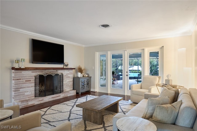 living room with light hardwood / wood-style flooring, a brick fireplace, and crown molding