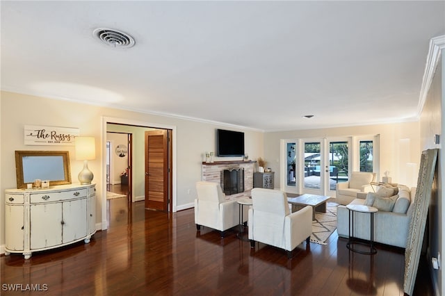 living room with dark hardwood / wood-style flooring, a brick fireplace, and crown molding