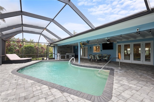 view of pool with a patio area, a lanai, ceiling fan, and french doors