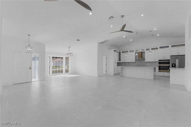 unfurnished living room with ceiling fan and vaulted ceiling