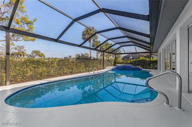 view of pool with a patio, glass enclosure, and an in ground hot tub