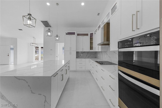 kitchen featuring light stone counters, hanging light fixtures, a spacious island, backsplash, and white cabinets