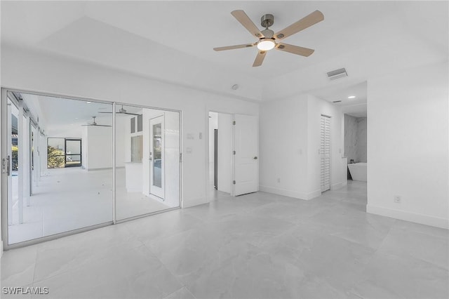 spare room with ceiling fan and a tray ceiling