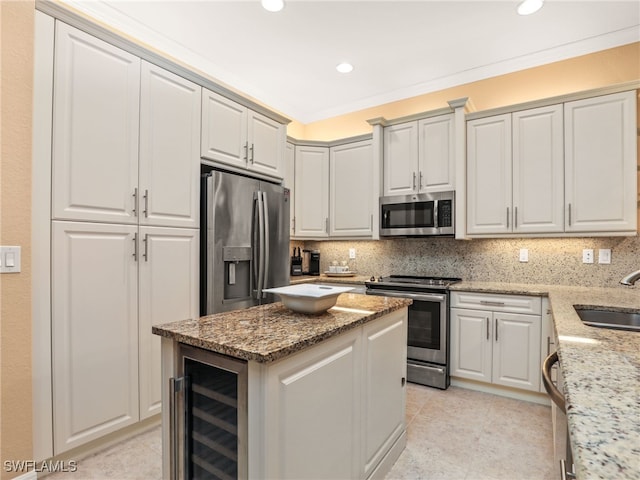 kitchen with stainless steel appliances, decorative backsplash, wine cooler, light stone countertops, and sink