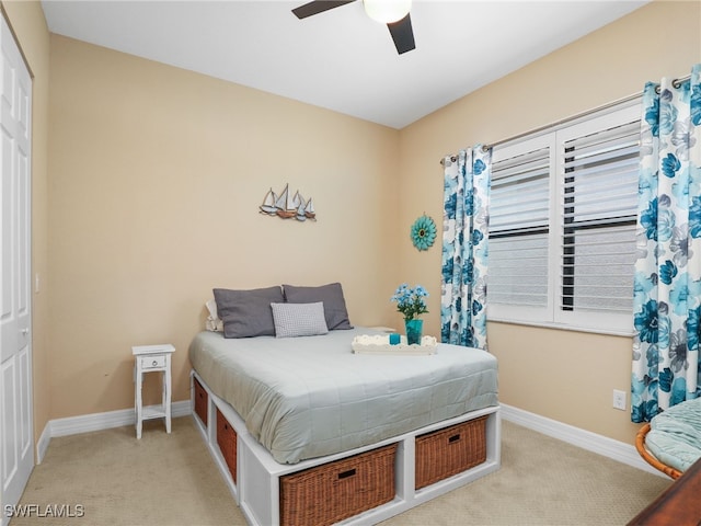 bedroom featuring light carpet, ceiling fan, and a closet