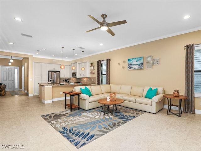 living room featuring ceiling fan and ornamental molding