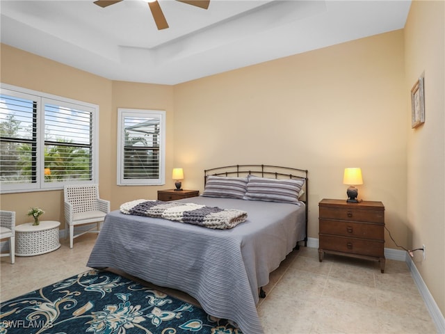 bedroom with ceiling fan and a tray ceiling