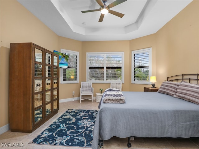 bedroom with ceiling fan and a tray ceiling