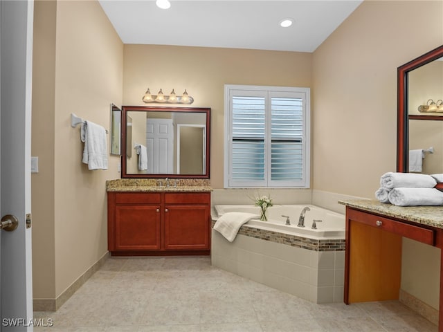 bathroom featuring tiled bath and vanity