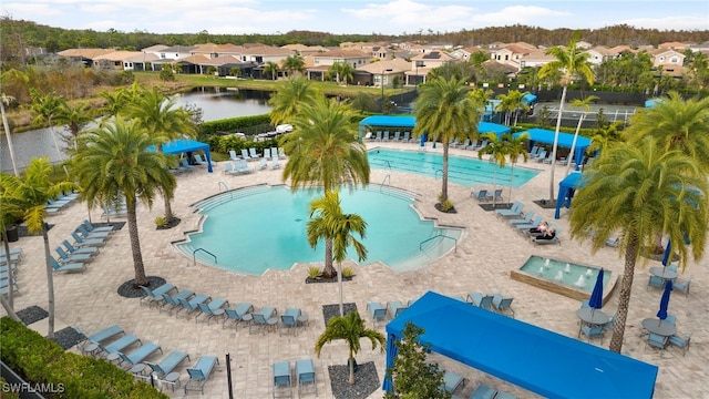 view of pool featuring a water view and a patio area