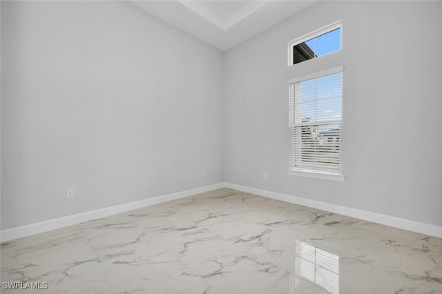 spare room with marble finish floor and baseboards