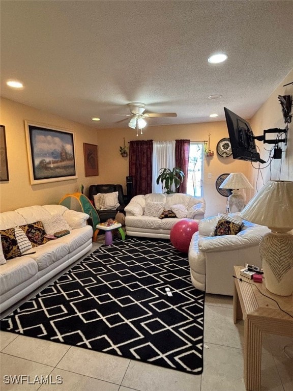 living room with a textured ceiling, ceiling fan, and light tile patterned floors