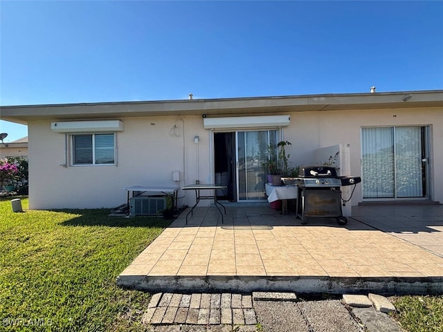 back of property with a patio, central AC, and a lawn