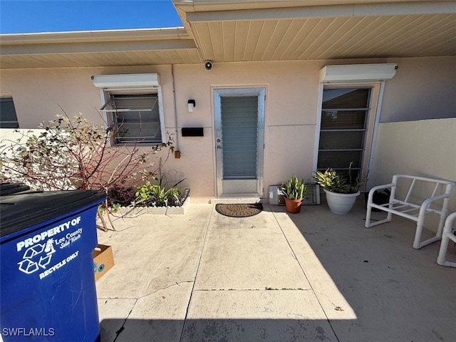 view of exterior entry with a patio area