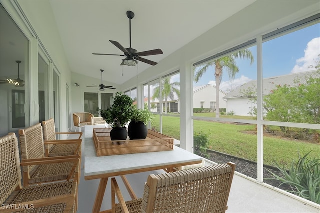 sunroom / solarium featuring vaulted ceiling, ceiling fan, and plenty of natural light