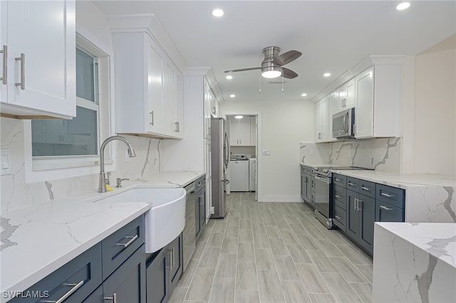 kitchen featuring appliances with stainless steel finishes, ceiling fan, white cabinets, and light stone countertops