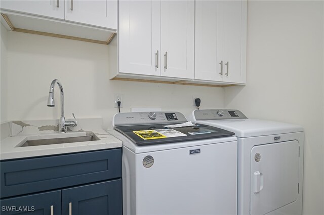 laundry area featuring cabinets, separate washer and dryer, and sink