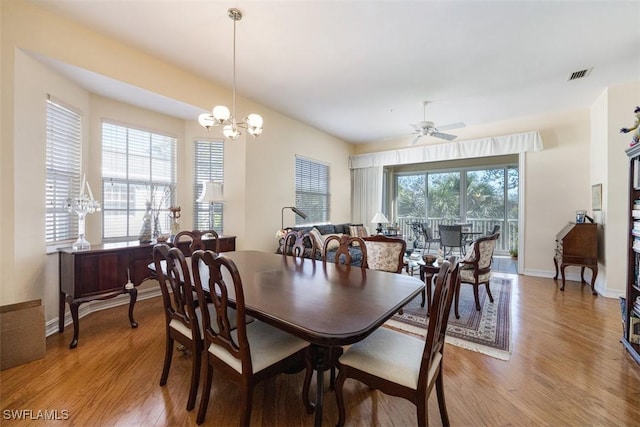 dining room with hardwood / wood-style flooring, ceiling fan with notable chandelier, and a wealth of natural light